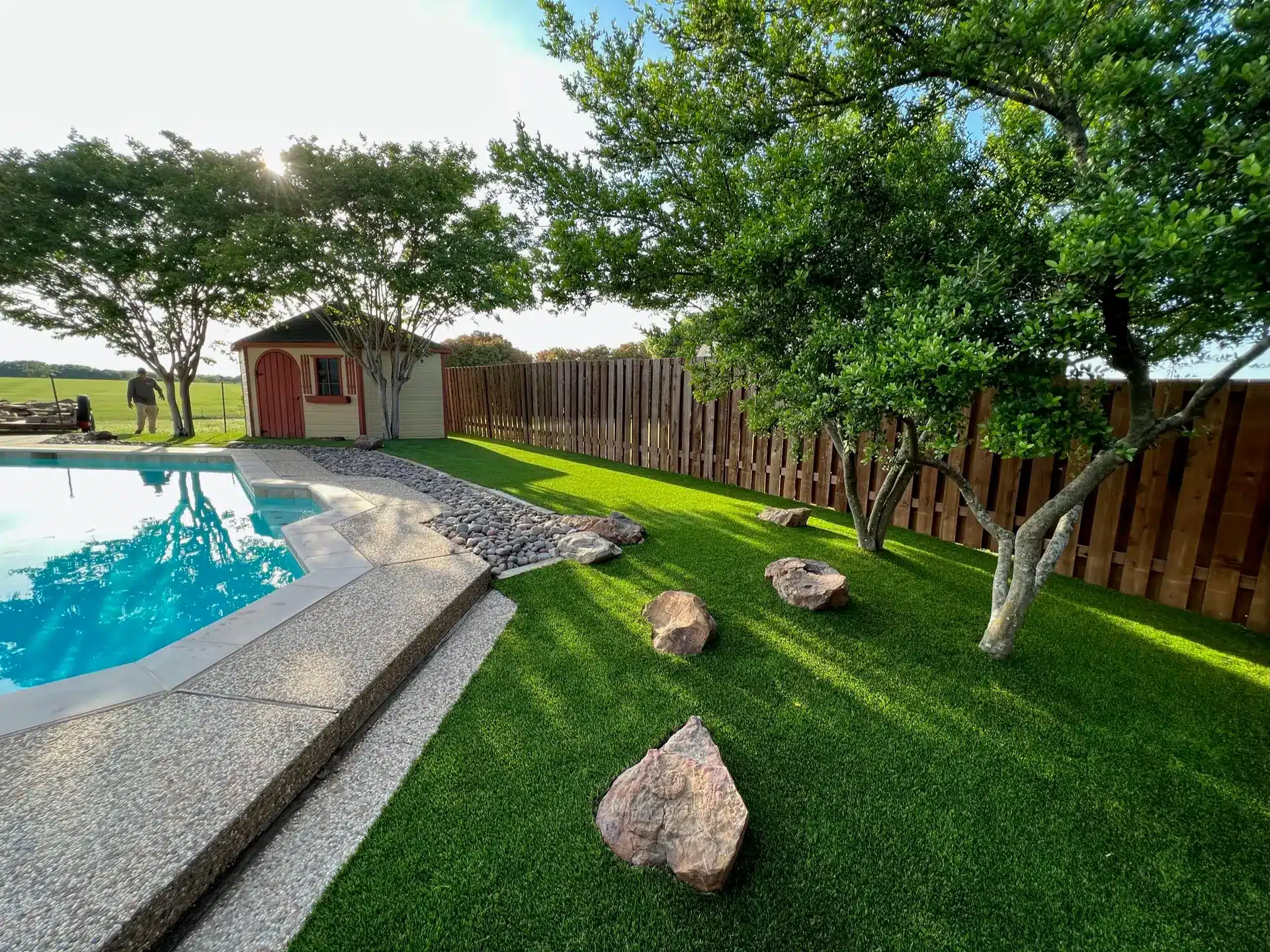 Turf blending like real grass around the pool and trees.