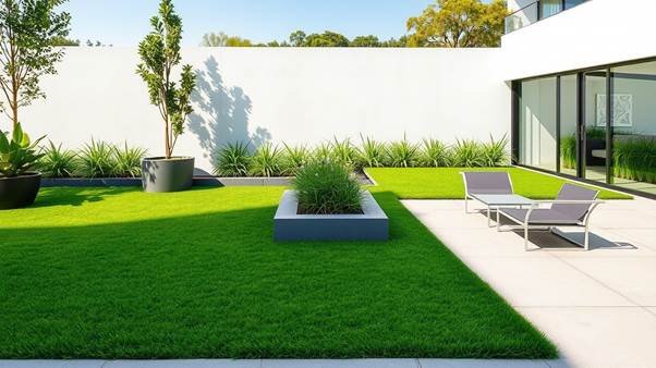 A modern backyard with lush artificial lawn grass turf surrounded by minimalist patio furniture and decorative potted plants.