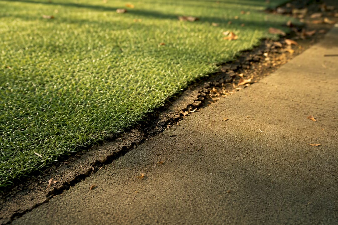 Sunlight highlights UV-damaged playground turf and shock pad
