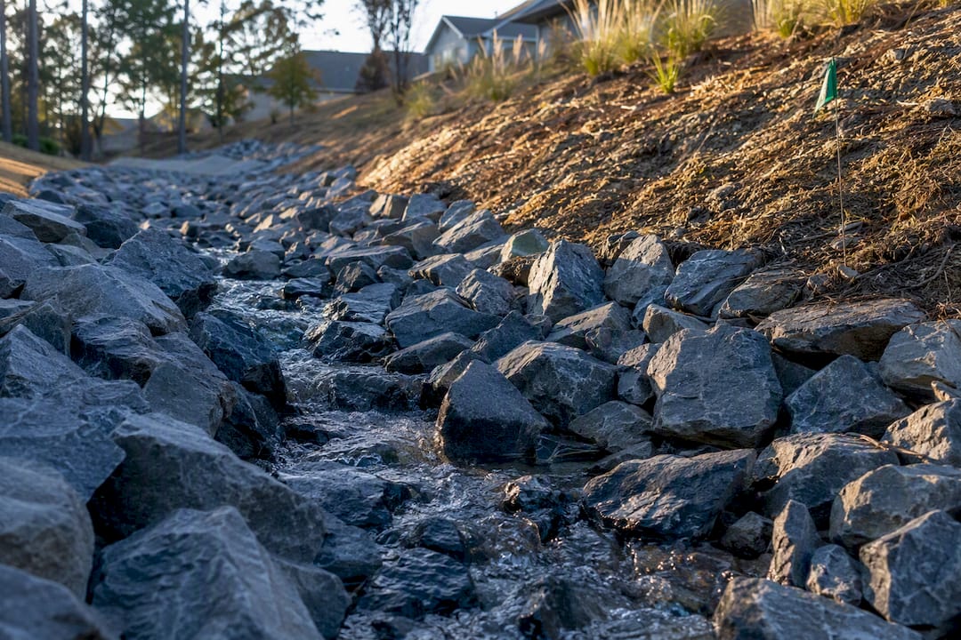 Riprap stabilizing a residential drainage swale